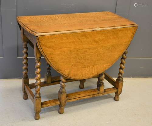 A reproduction oak drop-leaf table with barley twist legs, 73cm by 90cm by 41cm (leafs down)