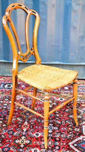 A Victorian bedroom chair with a rush seat, shaped back and turned leg and stretchers, 85cm tall.