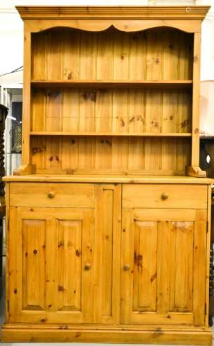 A pine dresser and rack, the enclosed having two shelves above two cupboards and single drawer,