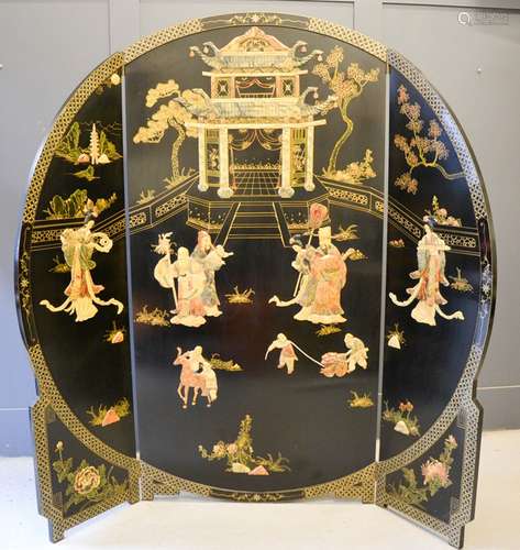 A large Chinese black lacquered tri-fold screen, depicting a Temple composed of carved soapstone,