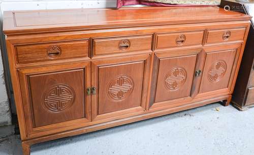 A 20th century Chinese rosewood sideboard with four drawers above corresponding cupboard doors