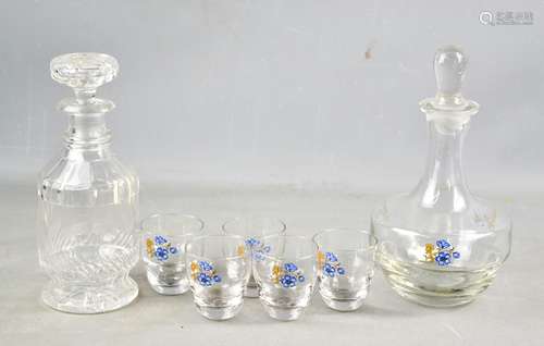 A cut glass decanter together with a 1950s glass decanter set, decorated with blue flowers.