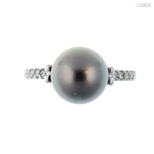 Bague en or gris centrée d’une perle noire épaulée…