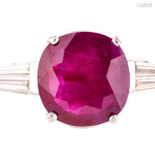 Bague en or gris centrée d’un rubis de taille oval…