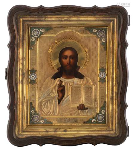 An Eastern European icon representing Christ with a gilt silver oklad and partially enamelled frame,