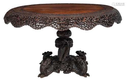 A richly carved Anglo-colonial exotic hardwood centre table, the openworked sides floral decorated,