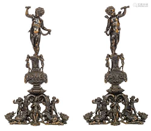 An impressive pair of Renaissance style patinated bronze andirons, topped with winged putti above an