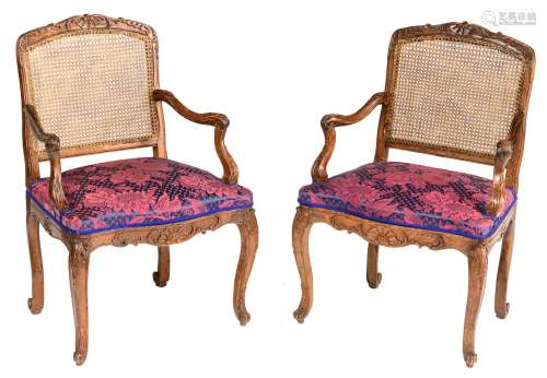 A fine pair of richly carved walnut Louis XV period armchairs, the seating upholstered with floral d