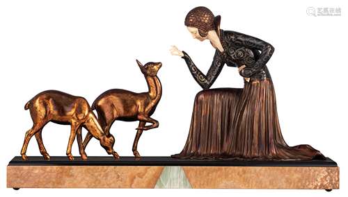 An Art Deco chryselephantine sculpture of a lady feeding deer, patinated spelter and ivory on an ony