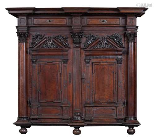 An imposing North German Baroque walnut 'Schrank', richly carved with sea Gods surrounded by angels,