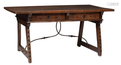 A Spanish Baroque walnut trestle (desk) table, decorated with carved geometric and stylized vine mot