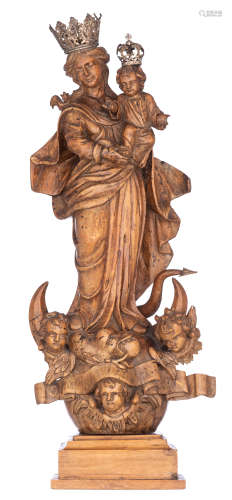 A walnut sculpture of the Madonna holding the Holy Child and standing on the crescent moon destroyin