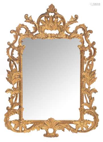 An Italian type wall mirror with a richly and baroque carved, gilt and patinated wooden frame, 78 x