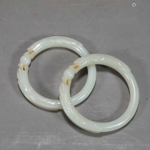 A PAIR OF DRAGON CARVED WHITE JADE BRACELETS