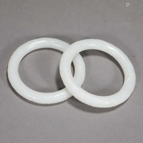 A PAIR OF FLOWER CARVED WHITE JADE BRACELETS