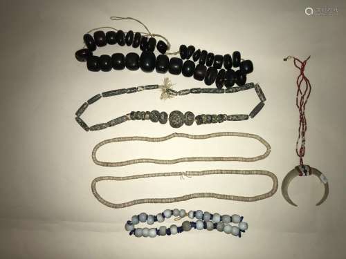 Un ensemble de 5 colliers de perles de bois et de pierre et deux dents de cochons AccidentsProvenance : Collection Michel Andrault (1926-2020)