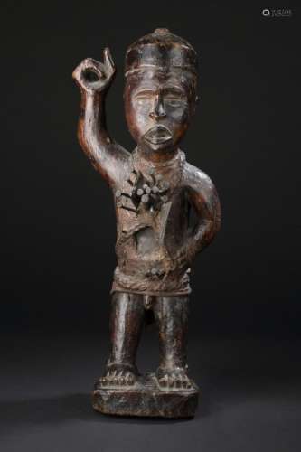 Statue Nkisi nkonde, République Démocratique du Congo Bois, fer, résine, clous, matériel féticheH. 48 cm Chez les Vili, la statuette dite nkisi nkonde a une fonction magico-religieuse servant de support et d'intermédiaire entre le monde des vivants et celui des esprits. Témoin et acteur de l'incessante lutte des forces qui régissent l'univers. Par son omniprésence au sein de la société, il participe aux rites d'initiation, aux cultes ancestraux et représente un important soutien au pouvoir politique. Elle manifeste, la beauté et la puissance et la complexité de la pensée Kongo.  Clous et charges multiples. Force d'expressivité des traits puissants. La pose telema lwimbanganga: le bras droit levé brandissant autrefois une arme, attitude sacrée adoptée par la noblesse Kongo et par les devins en signe d'autorité absolue.