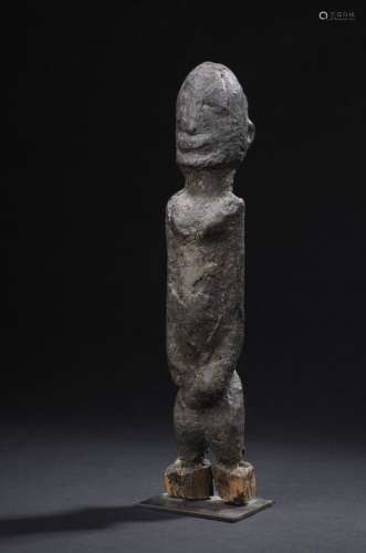 Statue Dogon, Mali H. 32 cmLes traits du visage effacés par une épaisse patine sacrificielle craquelée confèrent à cette statue féminine une profonde intériorité. Les mains jointes sous l'ombilic, le visage conique.