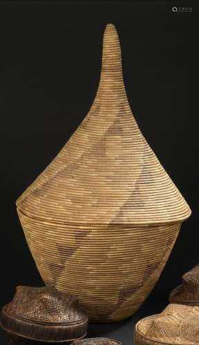 Panier de réserve Tutsi, Rwanda H. 70 cmPanier en vannerie. Le contenant, de forme cylindrique évasée, est décoré de frises géométriques noires. Le couvercle en forme d'entonnoir est caractéristique.