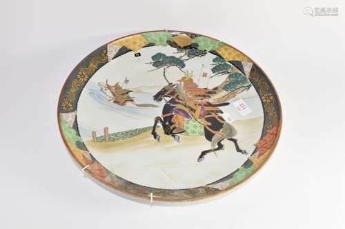 Japanese porcelain charger decorated with warriors on horseback, 38cm diam