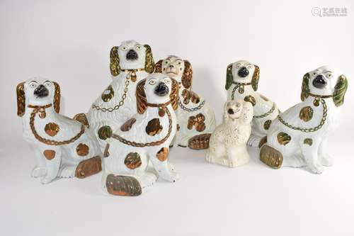 Group of seven Staffordshire dogs all with gilt highlights