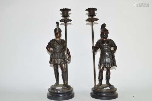 Two Roman warriors on circular bases holding candlesticks, 33cm high (2)