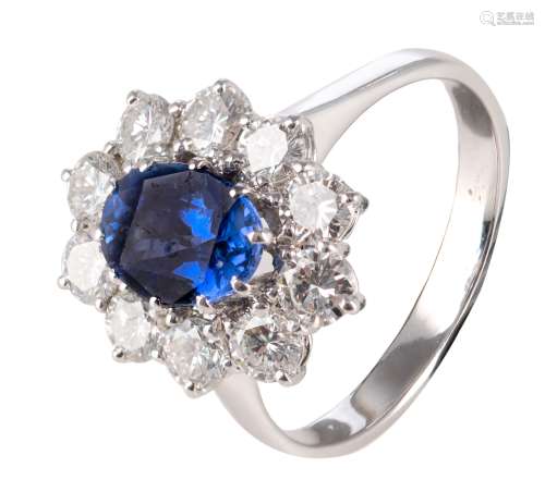 An 18ct white gold ring, central set with an oval cut sapphire and furthermore all-around mounted with 10 brilliant-cut diamonds, the total weight 4,8 g