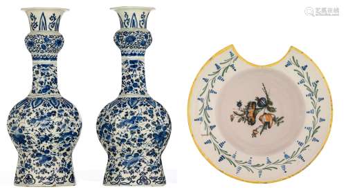 A pair of blue and white floral decorated Dutch Delftware garlic bottle vases, 18thC, H 37 cm. Added a polychrome decorated Northern France 'faïence populaire' barber bowl, 19thC, H 9,5 - ø 25,5 cm