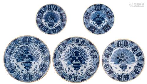 A collection of three large and two smaller blue and white 'peacock tail' decorated Dutch Delftware plates, two marked  'De Drie Klokken', two 'De Metaale Pot' and one 'De Klauw', 18thC, ø 23,5 - 34,5 cm