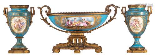 A three-piece soft-paste porcelain garniture in the Sèvres manner with gilt bronze mounts, with a blue céleste ground and polychrome decorated, the central piece with gallant scenes and the vases with putti and flower...