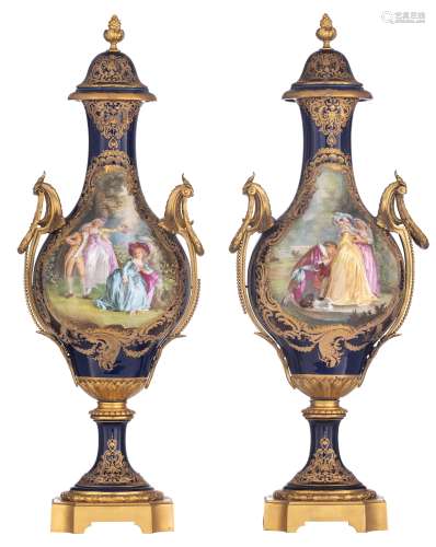 A pair of covered bleu royale ground Sèvres baluster-shaped vases with Neoclassical gilt bronze mounts, the roundels polychrome decorated with hand-painted gallant scenes of a romance between a young couple, signed by...