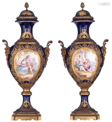 A pair of covered bleu royale ground Sèvres vases with Neoclassical gilt bronze mounts and satyr-shaped handles, the roundels polychrome decorated with hand-painted gallant scenes of a romance between a young couple, ...