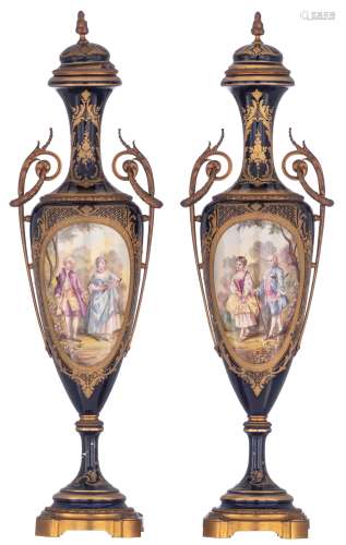A pair of covered bleu royale ground Sèvres vases with Neoclassical gilt bronze mounts, the roundels polychrome decorated with hand-painted gallant scenes of a romance between a young couple, signed K. Poitevin, the c...