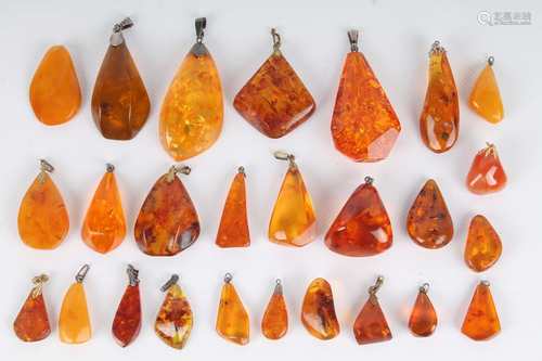 26 Bernstein Anhänger, teils mit Silber, 26 amber pendants, partly in silver,26 Berns