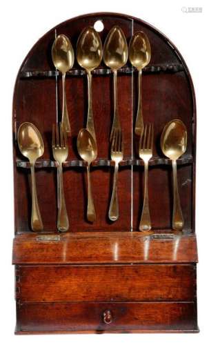 18世纪中叶的橡木挂式汤匙架，拱形背面，有12个汤匙孔，上面有一个盒子底座，有一个倾斜的铰链盖和一个抽屉，有10个镀金的汤匙和叉子(11) 57.5厘米高，33.4厘米宽，11.5厘米深 出处 已故简-萨姆纳的遗产。