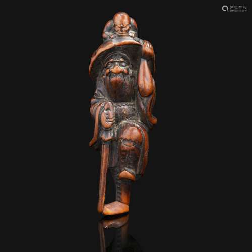 NETSUKE在木头上画着单脚站立的Choki，倚着剑，头顶着带鬼的帽子。签名被擦掉了不少，三哥？日本，江户时代，19世纪。高度：8厘米(3 1/8英寸)