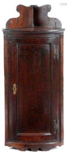 一件C.1740-50年的乔治二世橡木挂角柜，细长形，镶板门上方有一异形壁板，内有三层架子，高100.9厘米，宽44.5厘米，深31厘米。