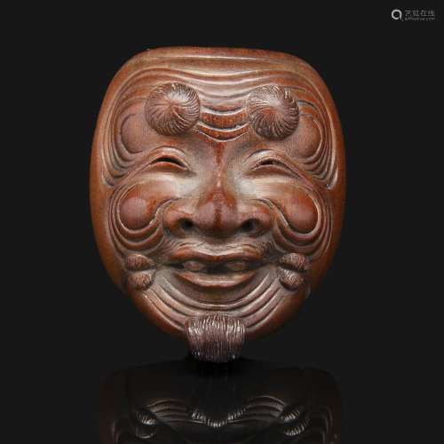 NETSUKE-MASK在黄杨木，代表冈那的面具，他的山羊胡子到后面。签名为Hôzan。日本，19世纪。盒式木制的冲绳网纹面具，日本，19世纪，签名为HÔZAN。顶部：3.5厘米(1 3/8英寸)