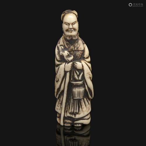 NETSUKE在鹿角中，代表着一个手持棍棒和花篮的中国圣人。未签署。日本，江户时代，19世纪。江户时代，江户时代，19世纪。高度：8.7厘米（3 7/16英寸）。