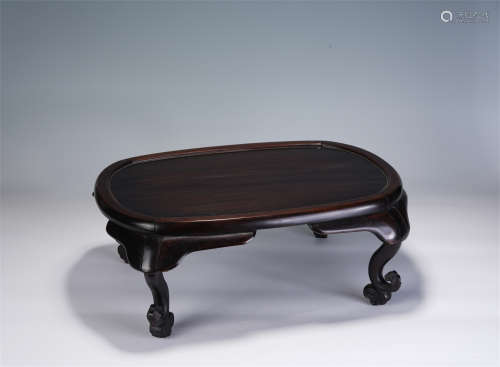 A CHINESE CARVED HARDWOOD OVAL-SHAPED TABLE