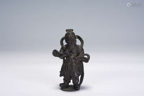 A CHINESE CARVED BRONZE STANDING FIGURE