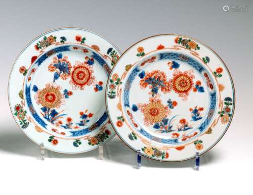 青花家圆瓷盘一对。  中国18世纪康熙时期（1662-1722）。赭石金盖下蓝色装饰，中间有牡丹花。翅膀上装饰着鲜花。直径：22厘米 一件有毛边和轻微的剥落。