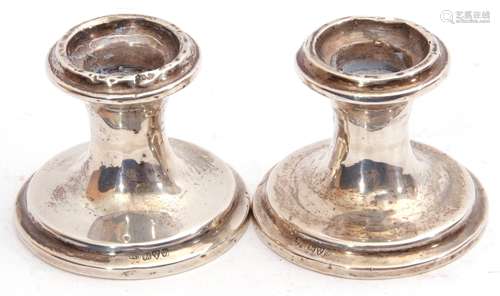 Pair of George V silver dwarf candlesticks of circular shape on stepped spreading loaded bases,