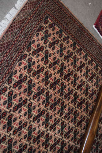 Modern Caucasian carpet, multi-gull border, central panel of geometric designs, mainly brown field