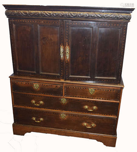 Early 18th century oak cabinet with chest base, having two inlaid double panelled doors beneath a