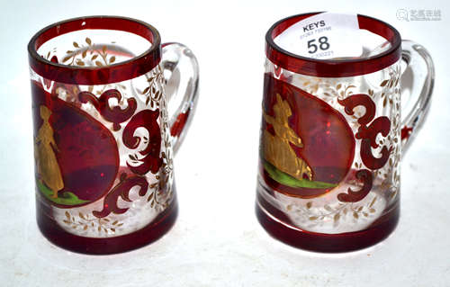 Two small glass tankards decorated in gilt with a young girl feeding birds, the other with a similar