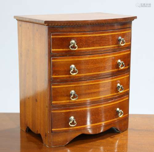 A BOW-FRONT MINIATURE CHEST OF DRAWERS