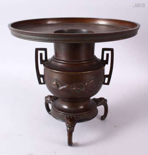 A 19TH CENTURY JAPANESE BRONZE TWO HANDLED VASE on three curving legs, with large circular top