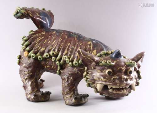 A CHINESE MOULDED POTTERY LION DOG, 48cm long.