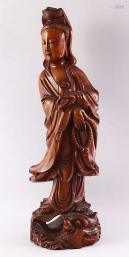 A GOOD LARGE CHINESE CARVED WOOD FIGURE OF GUANYIN, standing on a dragon, 55cm high.